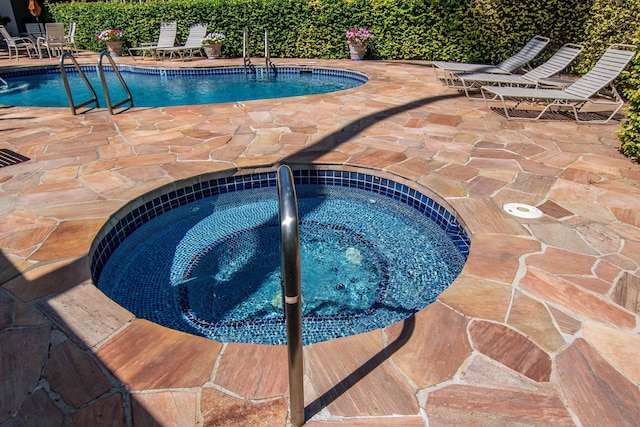 view of swimming pool featuring a community hot tub and a patio area