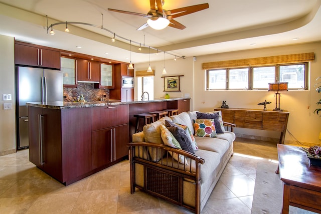 kitchen featuring tasteful backsplash, decorative light fixtures, track lighting, ceiling fan, and stainless steel appliances