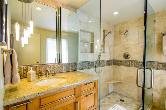 bathroom featuring walk in shower, vanity, and tasteful backsplash