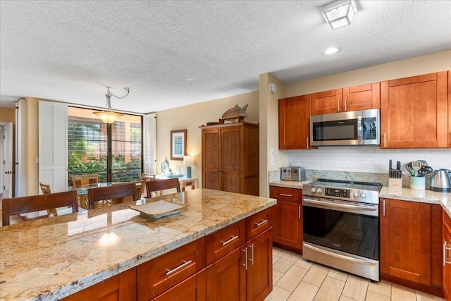 kitchen with backsplash, a kitchen bar, light stone counters, stainless steel appliances, and a textured ceiling