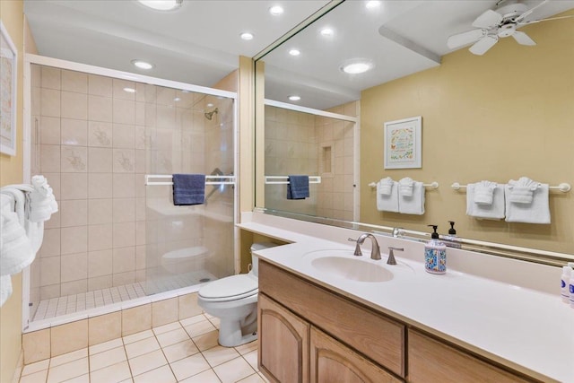 bathroom with a tile shower, vanity, tile patterned floors, and toilet