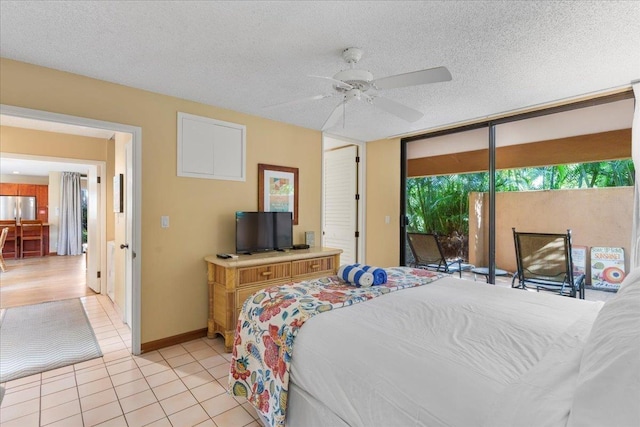 bedroom featuring stainless steel fridge, ceiling fan, access to exterior, a textured ceiling, and light tile patterned flooring