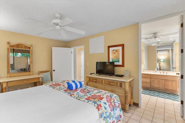 tiled bedroom with ceiling fan, sink, ensuite bath, and a textured ceiling