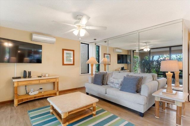 living room with hardwood / wood-style flooring, an AC wall unit, ceiling fan, and a wall of windows