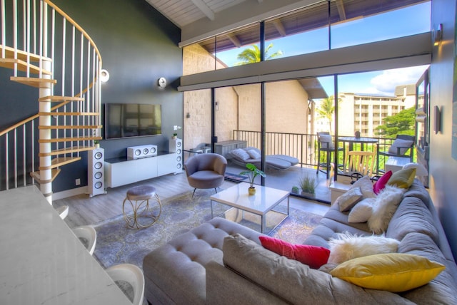 living room with beam ceiling, wood ceiling, wood finished floors, high vaulted ceiling, and stairs