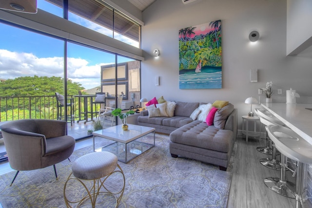 living area with high vaulted ceiling and wood finished floors