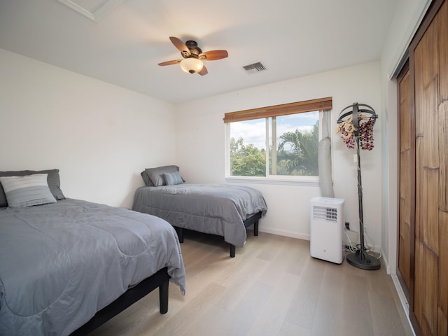 bedroom with a closet, ceiling fan, and light hardwood / wood-style flooring