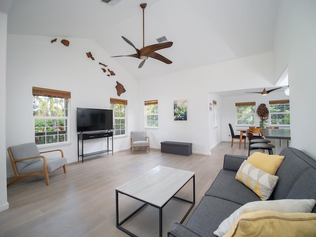 living room with ceiling fan, light hardwood / wood-style flooring, and high vaulted ceiling