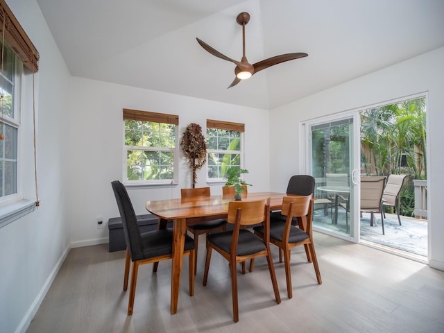 dining area with ceiling fan, vaulted ceiling, and light hardwood / wood-style floors