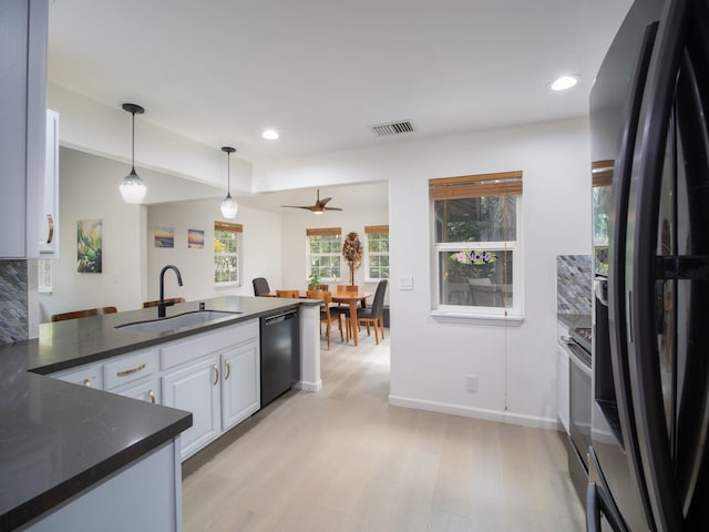 kitchen featuring white cabinets, pendant lighting, stainless steel fridge, ceiling fan, and sink