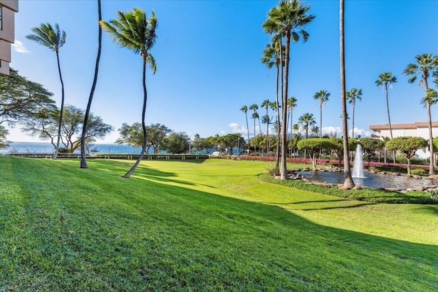 view of community with a lawn and a water view