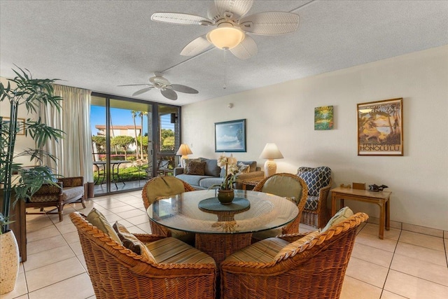 dining room featuring a textured ceiling, a ceiling fan, light tile patterned flooring, and expansive windows