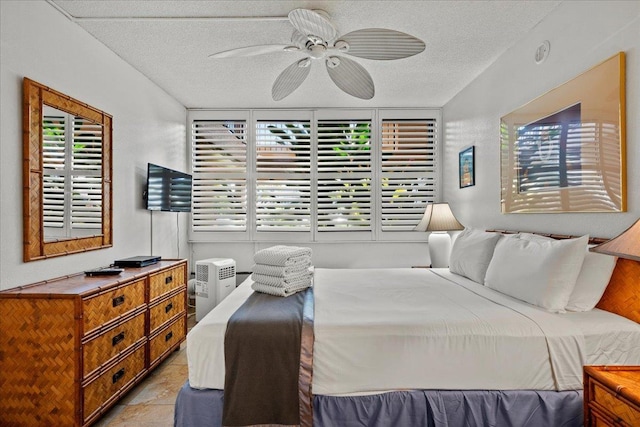 bedroom with a textured ceiling and multiple windows