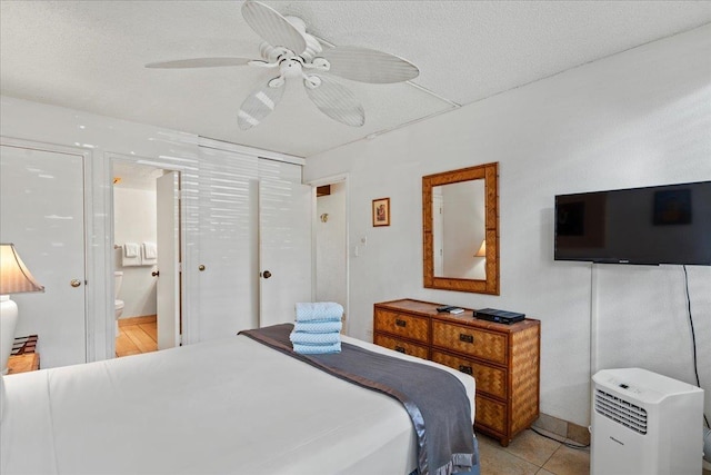 bedroom featuring a ceiling fan, a textured ceiling, and ensuite bath