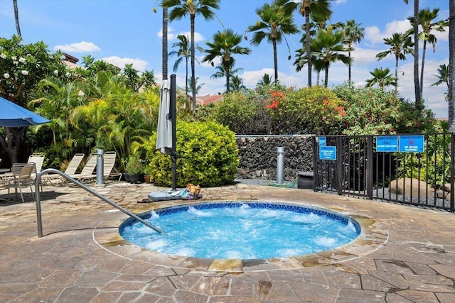view of pool featuring fence and a community hot tub