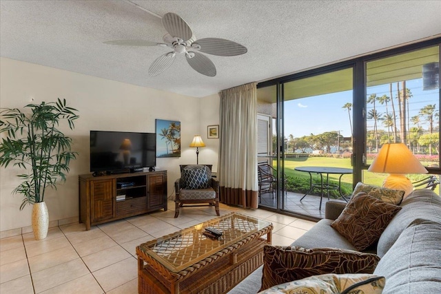 living room with light tile patterned flooring, a ceiling fan, floor to ceiling windows, and a textured ceiling