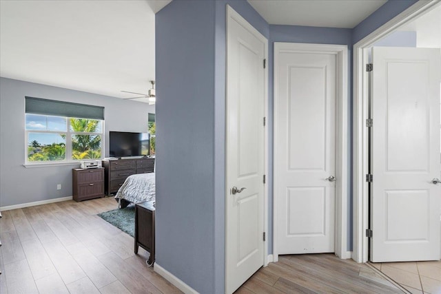 hall with baseboards and wood finished floors