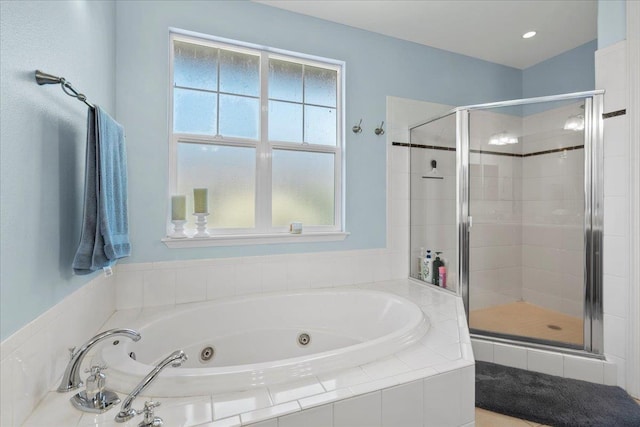 bathroom featuring a tub with jets and a shower stall