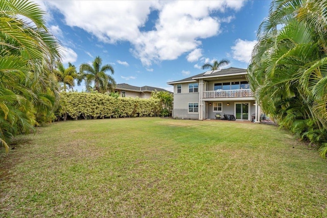 back of property featuring a balcony and a yard