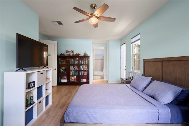 bedroom with visible vents, light wood-style flooring, a ceiling fan, and connected bathroom