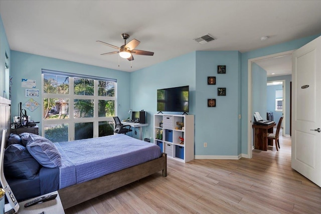 bedroom with baseboards, visible vents, light wood finished floors, and ceiling fan