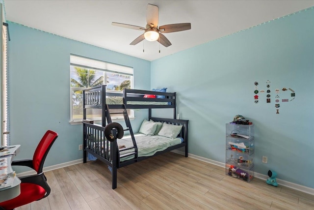 bedroom with ceiling fan, baseboards, and wood finished floors