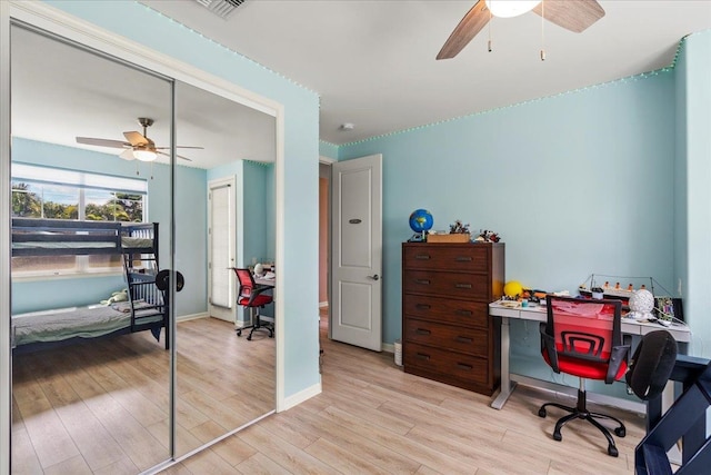 office area with light wood finished floors, visible vents, baseboards, and ceiling fan