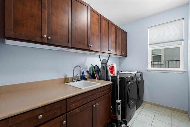 laundry room with a sink, cabinet space, light tile patterned flooring, and washing machine and clothes dryer