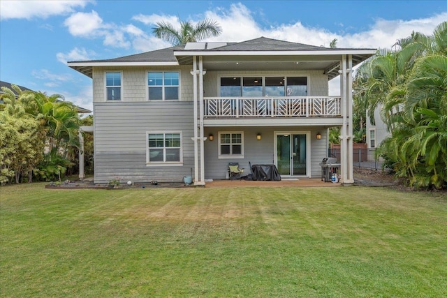 rear view of property with a patio area, a balcony, a lawn, and fence