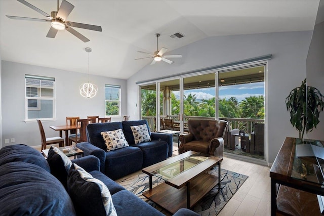 living area featuring vaulted ceiling, light wood-style flooring, visible vents, and ceiling fan