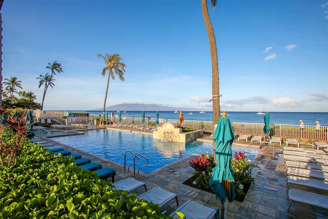 view of pool featuring a water view and a patio