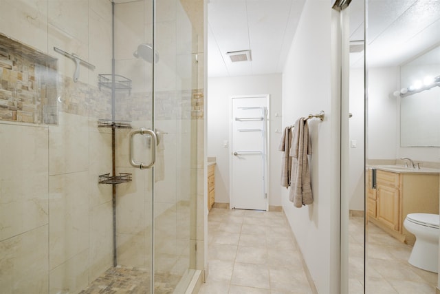 bathroom featuring tile patterned flooring, vanity, toilet, and an enclosed shower