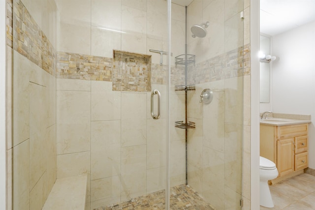 bathroom with tile patterned floors, vanity, toilet, and walk in shower