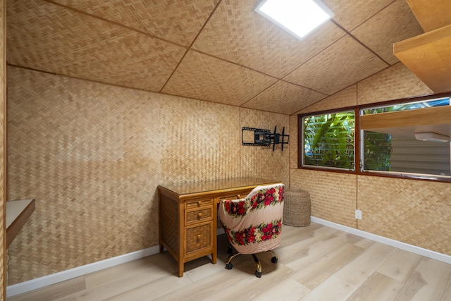 unfurnished office with wood-type flooring and vaulted ceiling