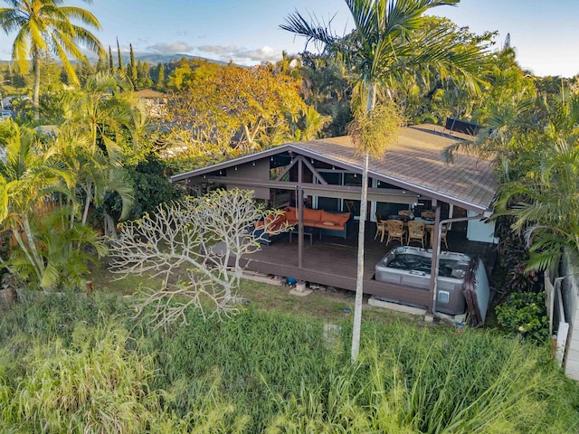 exterior space with a wooden deck, a hot tub, and an outdoor hangout area