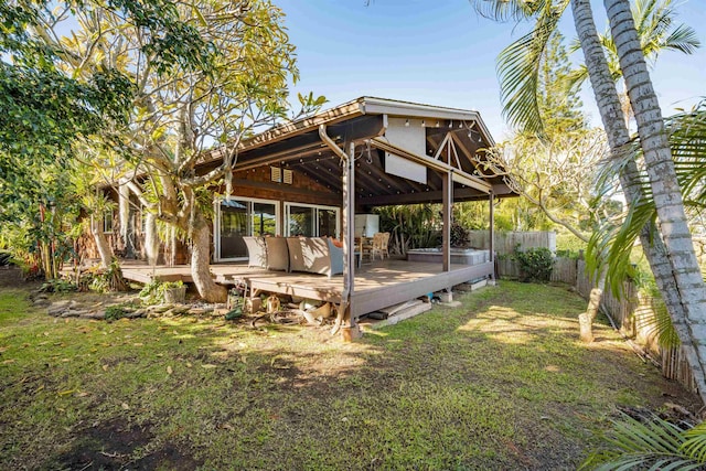 rear view of house with a deck and a lawn