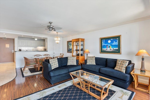 living room with crown molding, hardwood / wood-style flooring, and ceiling fan with notable chandelier