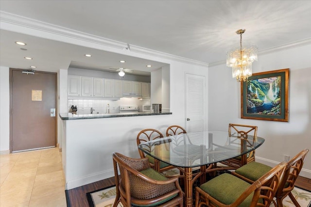 dining area with ceiling fan with notable chandelier and ornamental molding