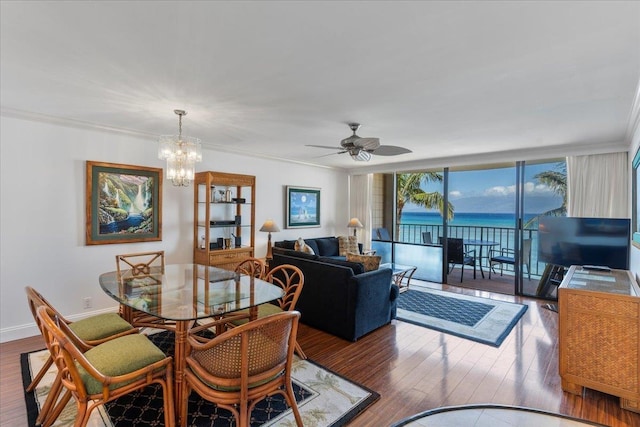 dining room with wood-type flooring, ceiling fan with notable chandelier, and crown molding