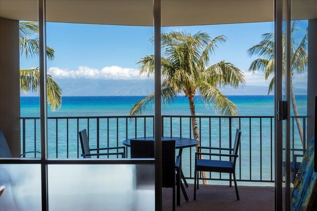 balcony with a water view and a beach view