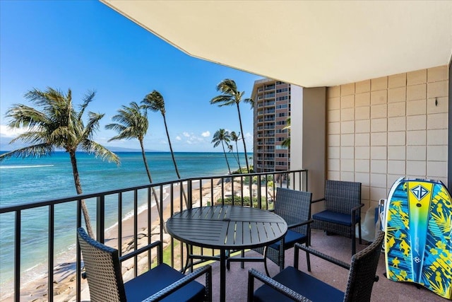 balcony featuring a water view and a beach view