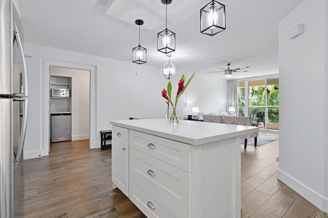 2575 S Kihei Rd Unit P-104, Kihei, HI 96753 - kitchen with freestanding refrigerator, wood finished floors, white cabinetry, and light countertops