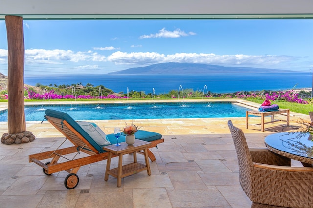 view of pool with pool water feature, a patio area, and a water and mountain view