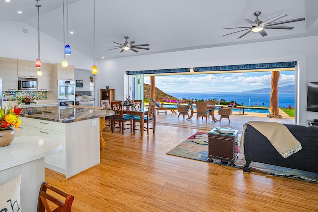 interior space with light hardwood / wood-style floors, high vaulted ceiling, and ceiling fan