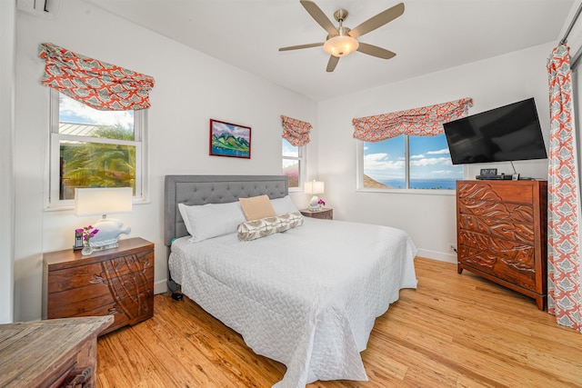 bedroom featuring multiple windows, ceiling fan, and light wood-type flooring