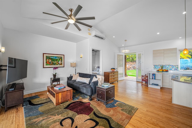 living room with a wall unit AC, ceiling fan, light hardwood / wood-style floors, and vaulted ceiling