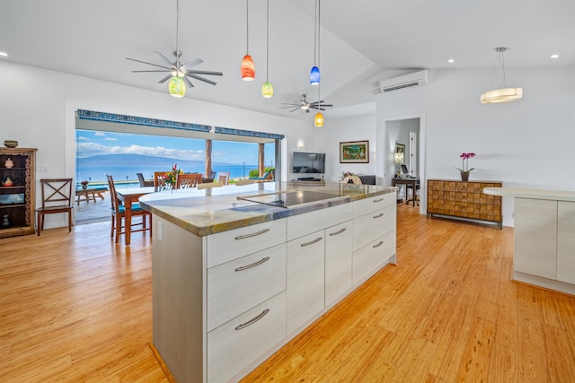 kitchen featuring white cabinetry, pendant lighting, lofted ceiling, and light wood-type flooring