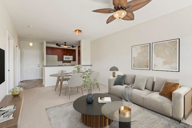 living area with light carpet and ceiling fan