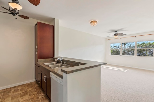 kitchen featuring a sink, dark countertops, baseboards, dishwasher, and a ceiling fan