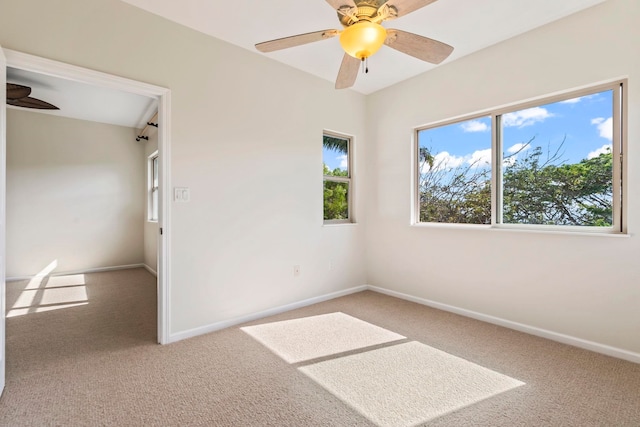 carpeted empty room with a ceiling fan and baseboards